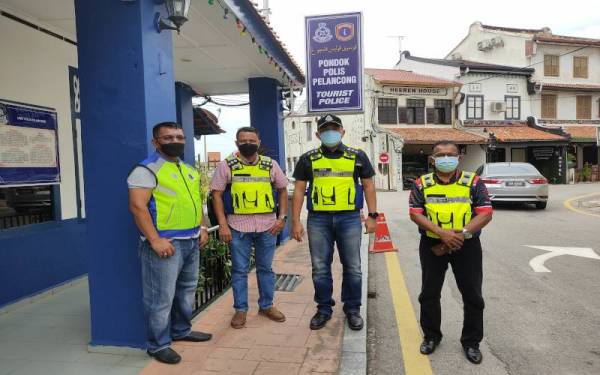 Afzanizar (dua kanan) bersama pegawai dan anggotanya ditemui Sinar Harian selepas rondaan SOP Covid-19 di sekitar Jonker Walk, pada Ahad.