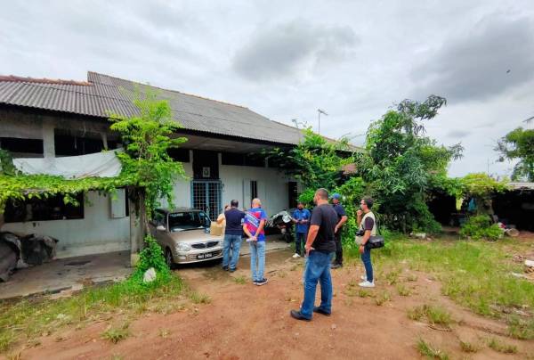 Mohd Azrudin (tengah) ketika meninjau kawasan banjir di Lorong Sarang Helang, Bachang, Melaka pada Ahad.