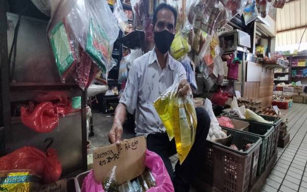 Mohd Fauzi menunjukkan minyak masak paket di sebuah kedai runcit di Pasar Besar Alor Setar pada Isnin yang dijual terhad satu paket sahaja kepada seorang pelanggan.