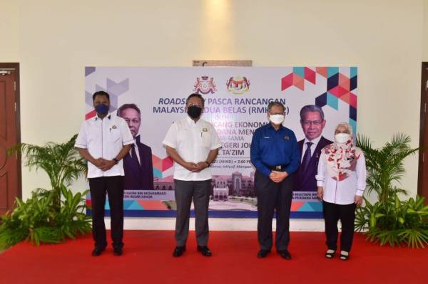 Mustapa (kanan) dan Hasni sebelum mendengar sesi taklimat program menangani kemiskinan di Iskandar Puteri dan Johor di Ibu Pejabat IRDA, Iskandar Puteri pada Ahad.