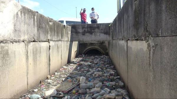 Sharudin (kanan) melihat pelbagai jenis sampah sarap yang terdapat di dalam longkang ketika mengadakan pemantauan kerja pembersihan longkang pada Selasa.