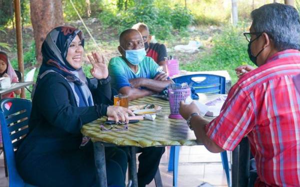 Mas Ermieyati bersama penduduk ketika bersarapan di sebuah warung di Tanjung Bidara, Alor Gajah pada Rabu.