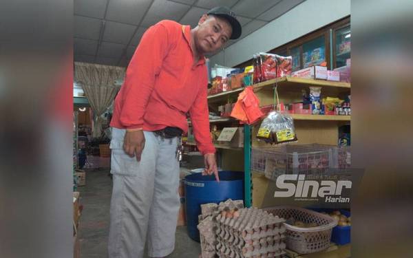 Mohd Fauzi menunjukkan telur ayam dijual di kedai runcitnya di Pasir Panjang, Sekinchan.