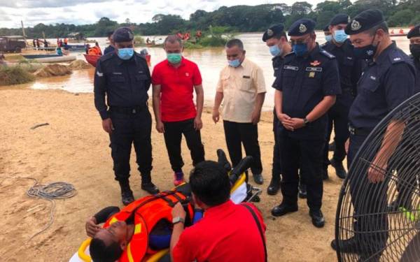 Ketua Polis Kelantan, Datuk Shafien Mamat (lima, kiri) melihat simulasi banjir membabitkan seorang mangsa yang diselamatkan oleh para anggota penyelamat.