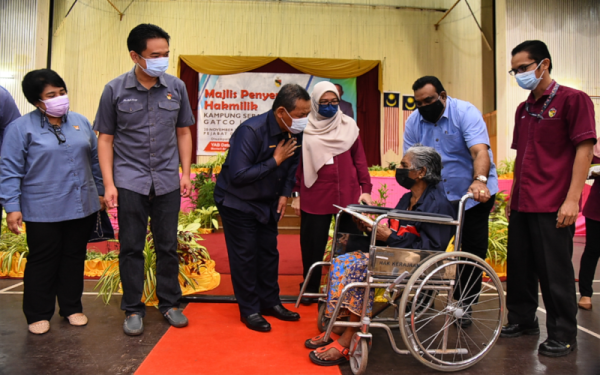 Aminuddin (tiga dari kiri) menyerahkan geran hak milik tanah ladang kepada penduduk Kampung Serampang Indah (Gatco) dalam satu majlis di Jempol pada Sabtu.