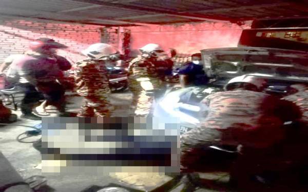 Anggota bomba sedang menjalankan kerja-kerja menyelamat bagi mengeluarkan mangsa yang dihempap sebuah kereta di Kampung Bayan Lepas, di sini pada malam Sabtu.