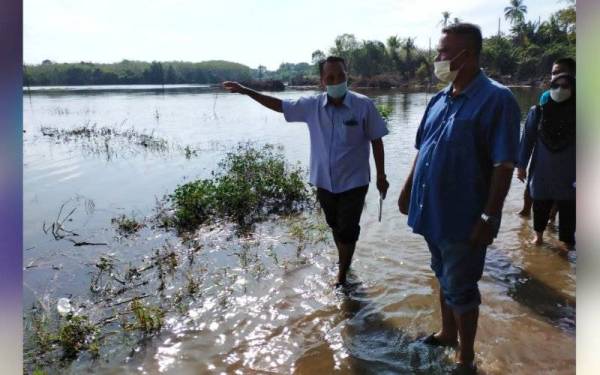 Johari (kiri) semasa turun padang melihat kawasan sawah padi yang ditenggelami banjir termenung di Rantau Panjang pada Ahad..