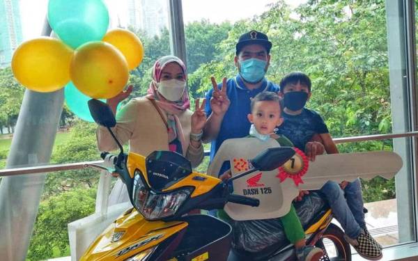 Siti Noradiana (kiri) bersama suami dan anak-anak bergambar bersama motosikal yang dimenanginya.