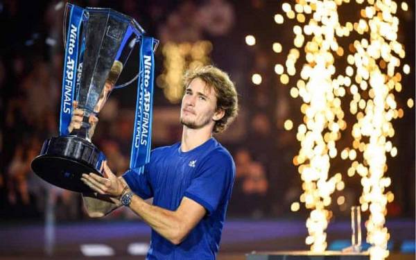 Zverev bersama trofi kejuaraan ATP Finals selepas menumbangkan Medvedev pada Ahad.