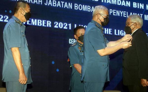 Mohammad Hamdan menyemat pingat kepada salah seorang anggota di Majlis Penganugerahan Pingat Kebesaran Jabatan dan Anugerah Perkhidmatan Cemerlang 2020 JBPM Pulau Pinang.