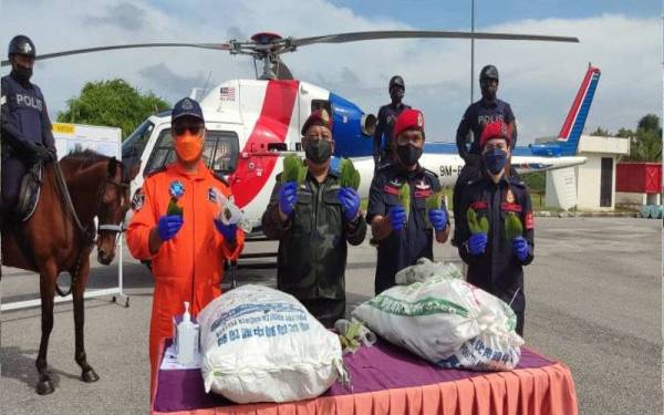 Azhar (dua kiri) dan Rosman (dua kanan) menunjukkan antara daun ketum yang berjaya dirampas oleh pihak berkuasa pada Op Benteng Kawalan Sempadan Darat Malaysia - Thailand di Bukit Kayu Hitam pada Selasa.