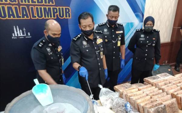 Timbalan Ketua Polis Kuala Lumpur Datuk Yahaya Othman (dua dari kiri) menunjukkan dadah dan peralatan memproses dadah yang dirampas dalam serbuan di ibu kota pada Rabu.