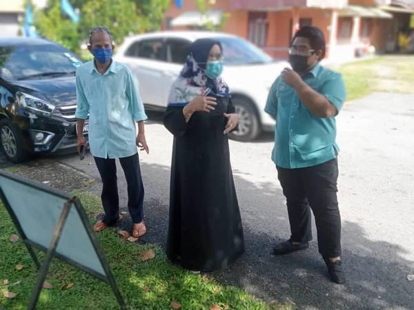 Kalsom (tengah) melihat sendiri keadaan sistem saliran di Kampung Peringgit, Melaka pada Rabu.