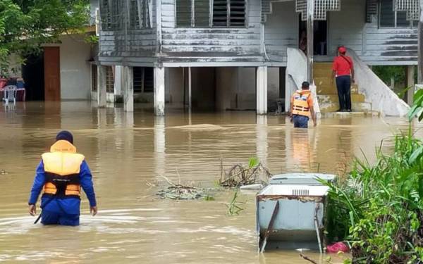 Anggota APM membantu pindahkan mangsa yang terjejas akibat banjir di daerah Hilir Perak. Foto: ihsan APM Perak.