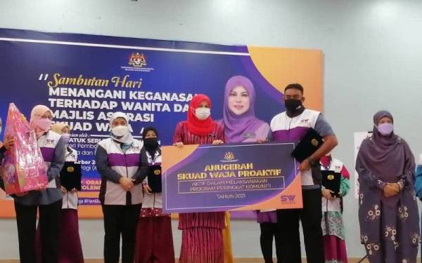 Rina (tengah) menyampaikan Anugerah Skuad Waja Prihatin pada Program Sambutan Hari Menangani Keganasan Terhadap Wanita dan Majlis Aspirasi Skuad Waja 2021 di Dewan Serbaguna Ampang Hilir di sini pada Khamis.