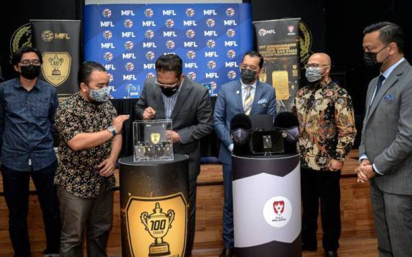 Ab Ghani (tiga dari kiri) melihat bar emas yang dipamerkan pada Pelancaran Set Komemoratif Edisi Terhad 100 Tahun Piala Malaysia di Wisma FAM hari ini. - Foto Bernama