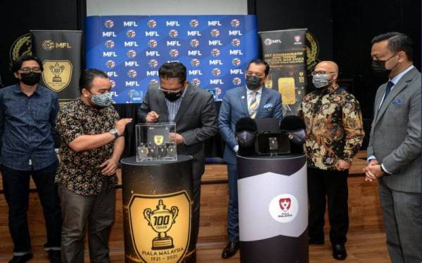 Ab Ghani (tiga dari kiri) melihat Bar Emas yang dipamerkan pada Pelancaran Set Komemoratif Edisi Terhad 100 Tahun Piala Malaysia di Wisma FAM pada Khamis. - Foto Bernama