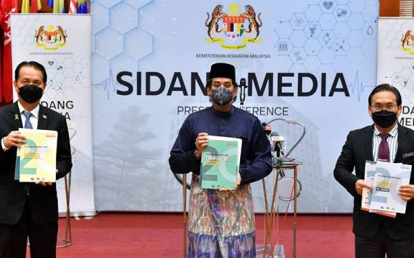 Khairy Jamaluddin (tengah) melancarkan buku 'Communicable Diseases' pada sidang media di Kementerian Kesihatan pada Jumaat. - Foto Bernama