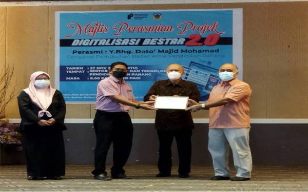 Majid (dua kanan) dan Mohammad Rosli (kanan) menyerahkan plak kepada SMK Beserah yang dijadikan hab digitalisasi pendidikan Badan Amal Pendidikan Pahang pada Majlis Perasmian Sistem Digitalisasi Bestar 2.0 di Dewan BTPN, pada Sabtu.