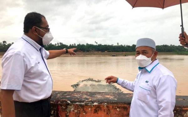 Tuan Ibrahim (kanan) menunjukkan denai yang dibina berhadapan Projek Penstabilan Tebing Sungai Kelantan di Kampung Pohon Celagi di Pasir Mas yang dilawati pada Ahad.