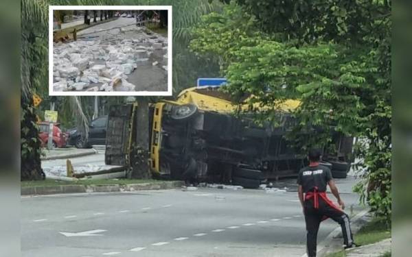 Lori treler bermuatan air minuman terbalik di persimpangan Taman Alam Budiman, Shah Alam pada Ahad. (Gambar kecil: Botol berisi air minuman yang bertaburan.)