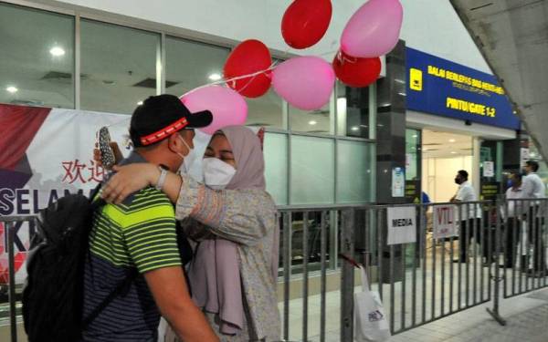 Mushaibah memeluk suaminya, Muhammad Wafi yang pulang ke Johor menerusi VTL Darat diTerminal Pengangkutan Awam Larkin Sentral di sini pada Isnin.