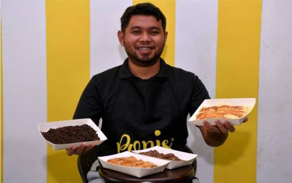 Muhammad Hanif menunjukkan produk makanan yang telah diinovasikan daripada makanan ringan popular dari Indonesia ketika ditemui di premisnya di Jalan Sultan Zainal Abidin di sini. - Foto Bernama 