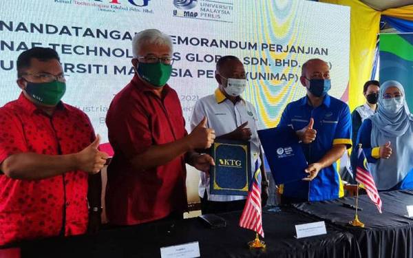 Zaliman (dua dari kanan) bertukar memorandum dengan Azman (dua dari kiri) ketika Program Menandatangani Memorandum Perjanjian KTG dan UniMAP di Taman Bersepadu Industri Kenaf (IKIP) di Batu Bertangkup Chuping pada Selasa.