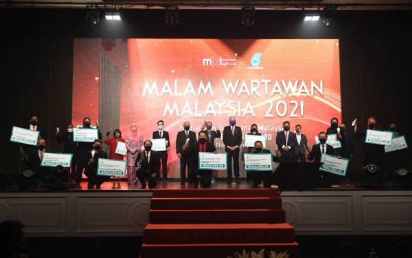 Perdana Menteri Datuk Seri Ismail Sabri Yaakob dan Ketua Setiausaha Kementerian Komunikasi dan Multimedia Datuk Seri Mohammad Mentek bergambar kenangan bersama para pemenang anugerah pada Majlis Malam Wartawan Malaysia 2021 di sebuah hotel pada Selasa. - Foto Bernama