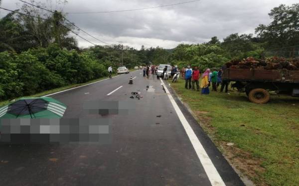 Mayat dua beradik tercampak di atas jalan akibat merempuh sebuah lori yang berundur. ( Foto ihsan PDRM)