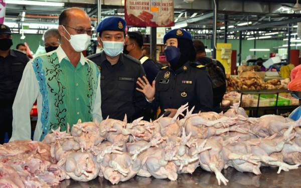 Ngwe Hee Sem (kiri) meninjau harga jualan ayam ketika melakukan lawatan di Pasar Besar MBMB hari ini. - Foto Bernama