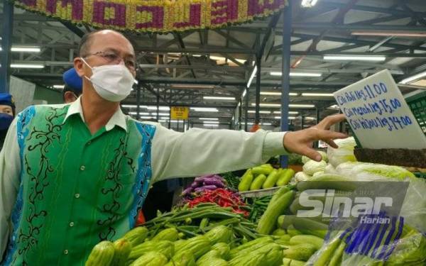 Hee Sem menunjukkan harga sayur yang mencecah berbelas ringgit di Pasar Besar MBMB di Bachang, Melaka pada Khamis.