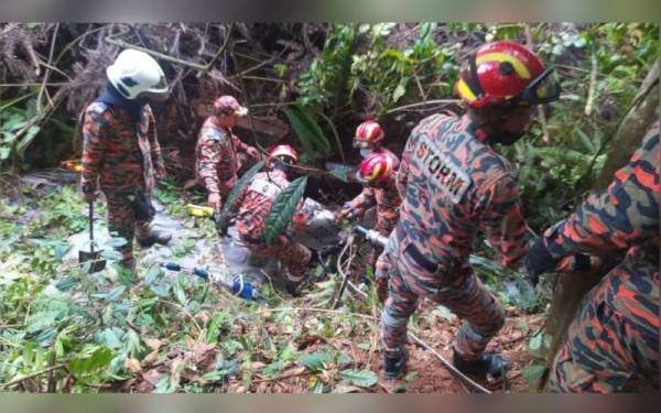 Pasukan STORM menjalankan operasi mengeluarkan mangsa yang tertimbus dalam sebuah kenderaan. - Foto ihsan Bomba Perak