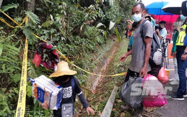 Penduduk orang asli menggunakan laluan hutan untuk pulang ke rumah masing-masing selepas Jalan Simpang Pulai-Blue Valley ditutup akibat tanah runtuh.