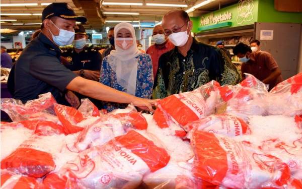 Exco Perpaduan Hubungan Masyarakat, Tenaga Kerja dan Hal Ehwal Pengguna negeri, Ngwe Hee Sem (kanan) dan ADUN Rim, Datuk Khaidhirah Abu Zahar (tengah) meninjau harga ayam ketika melawat ke sebuah pasar raya pada Jumaat. - Foto Bernama 