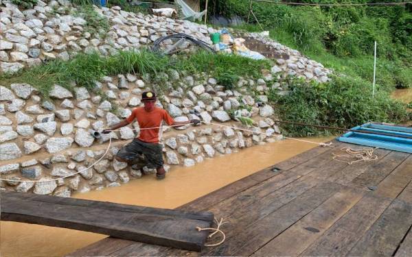 Sukri sentiasa bersedia untuk mengetatkan dan mengendurkan tali ikatan sangkar bagi memastikannya stabil dengan keadaan paras air semasa.