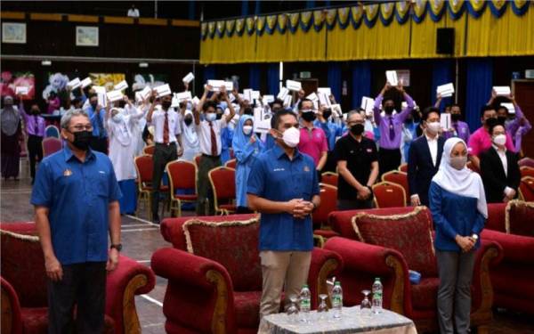 Mohd Radzi (tengah) bergambar bersama sebahagian pelajar yang menerima sumbangan tablet pada program ‘Aeon Sayap Bagimu’ di Institut Pendidikan Guru (IPG) Darul Aman, pada Sabtu.