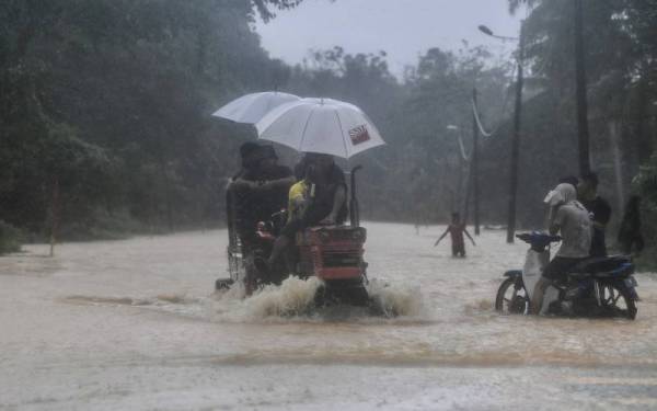 Sekumpulan lelaki menaiki traktor untuk meredah air akibat banjir semasa tinjauan di Kampung Lubuk Panjang, Mukim Chalok pada 3 Disember. - Foto Bernama