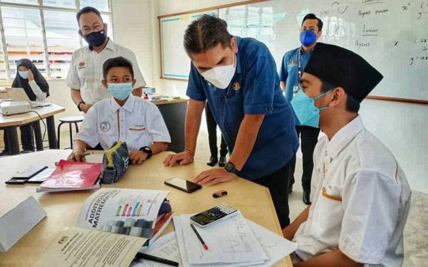 Mohd Radzi (dua dari kanan) beramah mesra dengan pelajar Akademi Sains Pendang selepas majlis perasmian akademi itu pada Ahad.