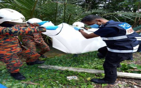 Anggota bomba dibantu polis mengangkat mayat kanak-kanak yang ditemukan dalam keadaan tidak sempurna di kawasan semak dalam sungai di Kampung Desa Makmur, Johor Bahru pada Sabtu
