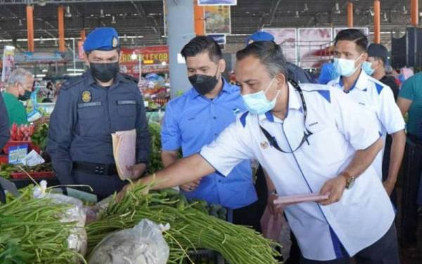 Pengarah KPDNHEPKelantan, Adnan Abd Rahman (tiga dari kiri) memantau harga sayur-sayuran pada Program Walkabout Skim Harga Maksimum Keluarga Malaysia KPDNHEP Kelantan di RTC Tunjong, Kota Bharu.