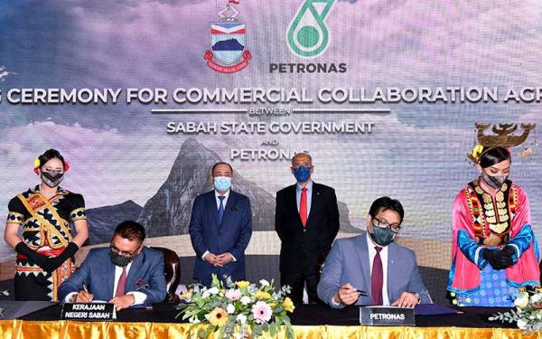 Hajiji Noor bersama Tan Sri Mohd Bakke Salleh (belakang, kanan) menyaksikan upacara menandatangani Perjanjian Kolaborasi antara Petronas dan kerajaan negeri Sabah. -Foto Bernama