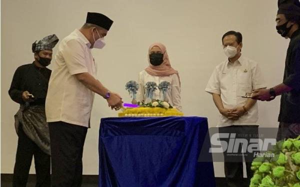 Izani memotong pulut kuning sebagai gimik perasmian majlis berkenaan.