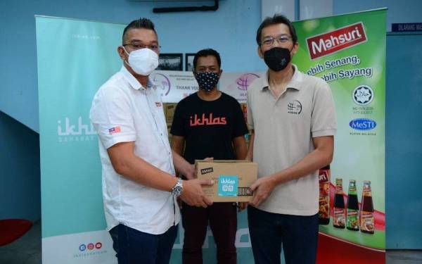 Mohd Jazri (kiri) menyerahkan produk Mahsuri kepada Jismi sambil disaksikan oleh Mohd Nor Effendi (tengah) di Kuala Lumpur pada Selasa.