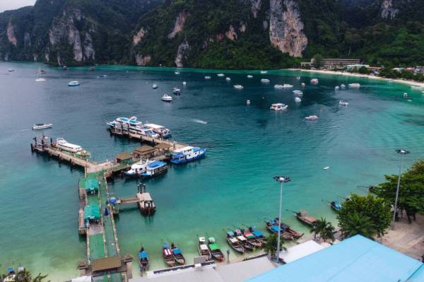 This aerial picture taken on November 26, 2021 shows the pier at Tonsai village on Thailand's Phi Phi Don island. - While travel stopped and the world locked down, in the dazzling blue waters of Thailand's idyllic Phi Phi islands, a gentle renaissance was under way. (Photo by Lillian SUWANRUMPHA / AFP) / TO GO WITH Thailand-environment-tourism-health-virus, FEATURE by Sophie Deviller and Thanaporn Promyamyai