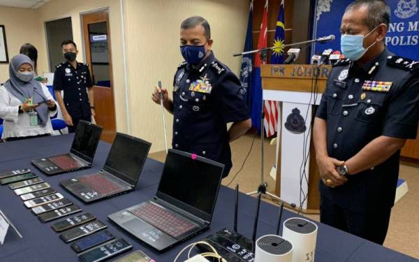 Ayob Khan (tengah) menunjukkan barangan yang dirampas dalam serbuan di sebuah rumah di Taman Ungku Tun Aminah, Johor Bahru pada Rabu