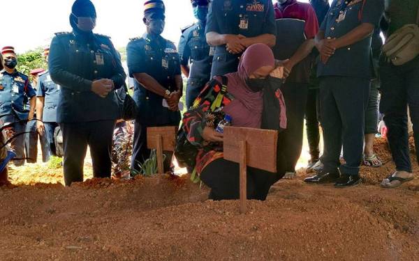 Nurul Jannah sebak ketika pengebumian suaminya, Mohd Firdaus yang meninggal dunia selepas terkena letupan ketika operasi memadam kebakaran di sebuah kilang.