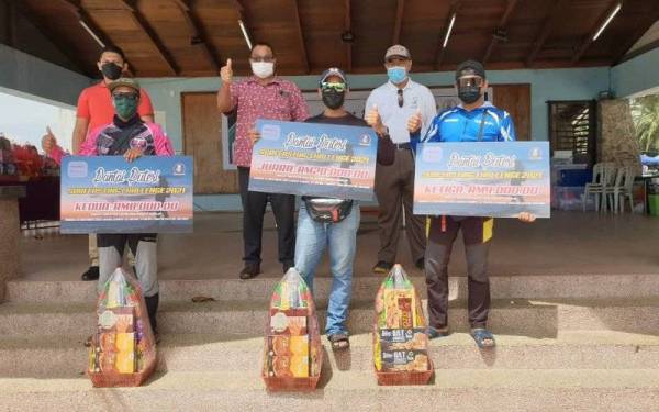 Husin (belakang, dua dari kiri) dan Muhammad Abdul Hafidz (belakang, kanan) bergambar bersama pemenang pertandingan Pantai Puteri Surfcasting Challenge 2021 yang diadakan di Melaka pada Ahad.