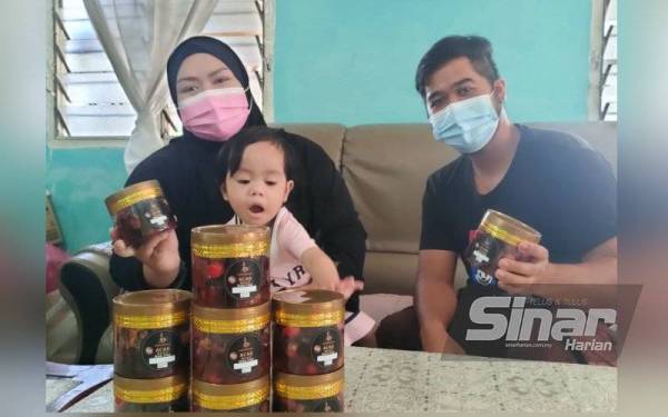 Nuridayu dan suaminya Alif Luqman menunjukkan acar buah Kak Pah yang dijual mereka untuk menambah dana kos pembedahan puteri sulung mereka.