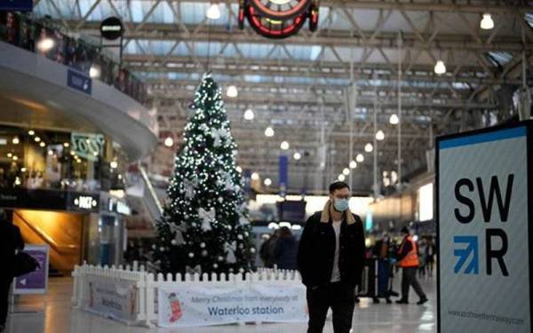 Seorang lelaki memakai pelitup muka ketika berada di stesen kereta api Waterloo di London. - Foto AP